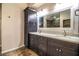 Elegant bathroom featuring dark wood cabinets, dual sinks, granite countertops, and tile floors for a sleek design at 309 Hidden Lake Dr, Brandon, FL 33511