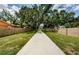 Brick walled walkway, green lawn, and shade trees along the long concrete driveway at 309 Hidden Lake Dr, Brandon, FL 33511