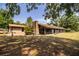 Rear exterior view of a brick home, showcasing its screened-in porch and spacious yard at 309 Hidden Lake Dr, Brandon, FL 33511