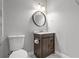 Bathroom features a round mirror and dark wood cabinet with a marble-patterned floor at 3138 Deergrass Ct, Holiday, FL 34691