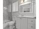 Modern bathroom with shower and tub, white vanity, toilet and ample lighting at 3138 Deergrass Ct, Holiday, FL 34691