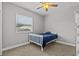 A cozy bedroom featuring a twin bed, ceiling fan, and natural light, with neutral paint at 3138 Deergrass Ct, Holiday, FL 34691