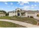 Stunning single-Gathering home with a well-manicured lawn, neutral color palette, and arched entryway at 3138 Deergrass Ct, Holiday, FL 34691