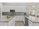 Bright kitchen featuring white cabinets, granite countertops, and stainless steel appliances at 3138 Deergrass Ct, Holiday, FL 34691