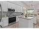 Contemporary kitchen with white cabinets, stainless steel appliances, and a center island at 3138 Deergrass Ct, Holiday, FL 34691