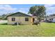 Spacious backyard featuring an AC unit, lush green grass, and a sturdy fence for privacy and security at 3201 E Mcberry St, Tampa, FL 33610