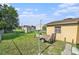 Spacious backyard with a large grassy area, storage shed, trailer, and convenient alley access at 3201 E Mcberry St, Tampa, FL 33610