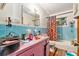 Small bathroom with blue tile, pink vanity, bathtub with shower and floral patterned shower curtain at 3201 E Mcberry St, Tampa, FL 33610