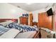 Bedroom featuring a full bed, wooden dressers and side tables, wall mounted television and closet at 3201 E Mcberry St, Tampa, FL 33610