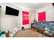 Bedroom featuring a double bed with wood frame, side table, and a wall mounted television at 3201 E Mcberry St, Tampa, FL 33610