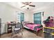 Modest bedroom featuring a twin bed, desk and chair, ceiling fan and small window at 3201 E Mcberry St, Tampa, FL 33610