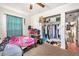 Bedroom with twin bed, ceiling fan, and filled closet with long hallway view at 3201 E Mcberry St, Tampa, FL 33610