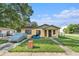Charming bungalow with a well-maintained lawn and covered car during the day at 3201 E Mcberry St, Tampa, FL 33610