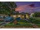 Charming bungalow with a well-maintained lawn and covered car at sunset at 3201 E Mcberry St, Tampa, FL 33610