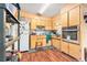 Retro kitchen featuring wood cabinets, matching backsplash, modern stainless steel oven and hardwood floors at 3201 E Mcberry St, Tampa, FL 33610