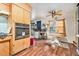 Kitchen area featuring wood cabinets, modern stainless steel oven, table and chairs, and hardwood floors at 3201 E Mcberry St, Tampa, FL 33610
