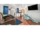 Open living room featuring wood-look floors, a flat-screen TV, and natural light at 3201 E Mcberry St, Tampa, FL 33610