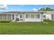 Manicured backyard featuring a screened-in porch, stone accents, and lush green grass at 3271 Mcmath Dr, Palm Harbor, FL 34684