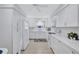 Modern kitchen with white cabinetry, countertops, stainless steel appliances, and ample storage space at 3271 Mcmath Dr, Palm Harbor, FL 34684
