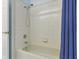 Bathroom featuring a shower and bathtub with a white tile surround and blue shower curtain at 3457 Foxhall Dr, Holiday, FL 34691