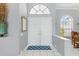 A foyer with gray walls, white trim and white double doors with an arched window above the doorway at 3457 Foxhall Dr, Holiday, FL 34691