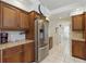 Kitchen boasts stainless steel refrigerator, granite counters, and ample cabinet storage at 3457 Foxhall Dr, Holiday, FL 34691