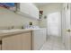 Laundry room with a white washer and dryer, a sink, and white cabinets for storage at 3457 Foxhall Dr, Holiday, FL 34691