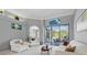 Bright living room featuring neutral decor, comfortable seating and sliding glass doors leading to the pool at 3457 Foxhall Dr, Holiday, FL 34691
