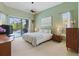 Bedroom with ceiling fan, and sliding glass doors to a screened pool area at 3457 Foxhall Dr, Holiday, FL 34691