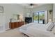 Bright bedroom with pool view, dresser, and neutral walls at 3457 Foxhall Dr, Holiday, FL 34691