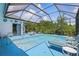 A screened in pool area featuring clear blue water, lounge chairs, and a table with chairs at 3457 Foxhall Dr, Holiday, FL 34691