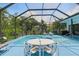 A screened in pool area with white patio furniture and a view of the surrounding yard at 3457 Foxhall Dr, Holiday, FL 34691