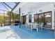 Screened pool area with a hot tub, dining table, and lush landscaping at 3457 Foxhall Dr, Holiday, FL 34691