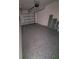 View of the spacious garage featuring a garage door, epoxy floor and room for storage at 3713 N 31St St, Tampa, FL 33610