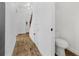 Hallway features wood-look floors, white walls, and access to a powder room and staircase at 409 S Audubon Ave # 3, Tampa, FL 33609
