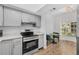 Modern kitchen featuring gray cabinets, stainless steel appliances, and countertops with stylish gold hardware at 409 S Audubon Ave # 3, Tampa, FL 33609