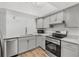 Modern kitchen featuring gray cabinets, stainless steel appliances, and countertops with stylish gold hardware at 409 S Audubon Ave # 3, Tampa, FL 33609