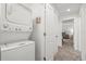 Hallway view of a stacked washer and dryer with white cabinets and access to more rooms at 4206 W North B St # 1, Tampa, FL 33609