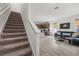 Open living area with stairs, a modern sofa, a kitchen with a breakfast bar, and tile floors at 4206 W North B St # 1, Tampa, FL 33609