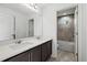Double vanity bathroom, featuring white quartz countertops, dark cabinets, and a view of the tiled shower and tub at 4206 W North B St # 2, Tampa, FL 33609