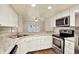 Updated kitchen with stainless steel appliances, granite counters, and white cabinets open to the living area at 4342 Candler Ave, Spring Hill, FL 34609