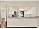 Open kitchen featuring white cabinets, granite countertops, stainless steel appliances, and a breakfast bar at 4342 Candler Ave, Spring Hill, FL 34609