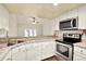 Updated kitchen with stainless steel appliances, granite counters, and white cabinets open to the living area at 4342 Candler Ave, Spring Hill, FL 34609