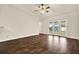 Bright living room with hardwood floors, ceiling fan, and access to the backyard through French doors at 4342 Candler Ave, Spring Hill, FL 34609