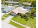 Aerial view of a well-maintained home with a screened-in pool and lush landscaping in a quiet neighborhood at 460 Meravan Dr, Palm Harbor, FL 34683