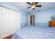 A blue bedroom features hardwood floors, double closets, and an overhead ceiling fan at 460 Meravan Dr, Palm Harbor, FL 34683