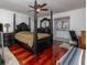 Bedroom boasts a dark wood four poster bed, hardwood floors, and an en suite bathroom at 460 Meravan Dr, Palm Harbor, FL 34683