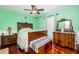 Bedroom with wood furniture and wood floors features a ceiling fan and natural light at 460 Meravan Dr, Palm Harbor, FL 34683