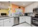 Updated kitchen with stainless steel appliances, white cabinetry, and stylish backsplash for the discerning chef at 460 Meravan Dr, Palm Harbor, FL 34683