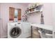 Functional laundry room with modern washer/dryer, shelving, and folding area for convenient chores at 460 Meravan Dr, Palm Harbor, FL 34683